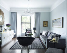 A living room with grey walls and black furniture.