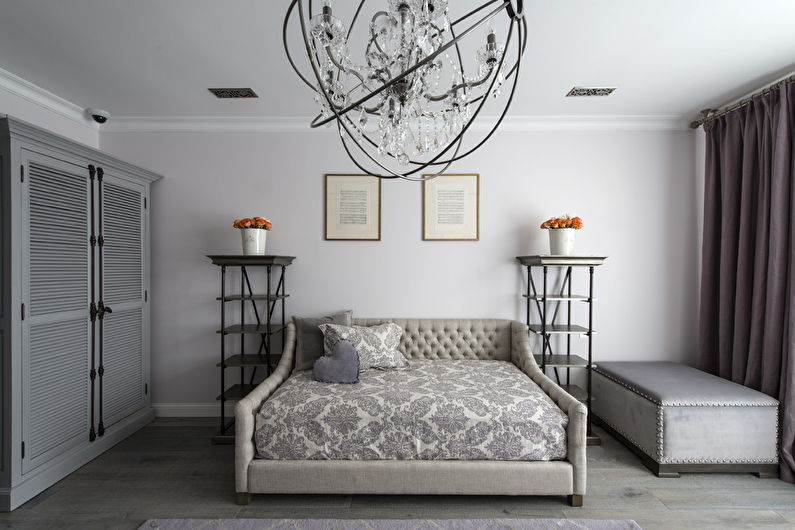 A bedroom with a bed and a chandelier.