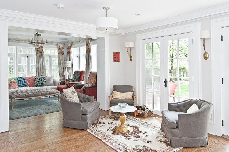 A living room with two chairs and a rug.