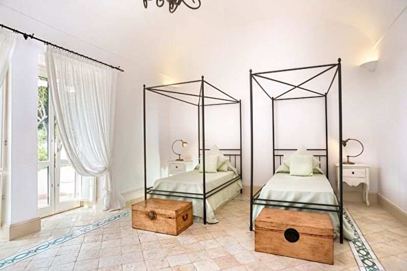 Two beds in a room with a chandelier.