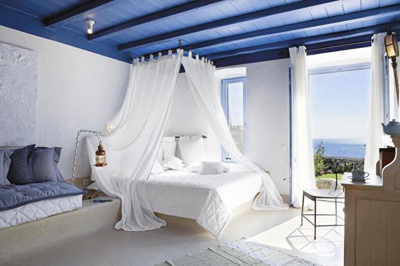 A bedroom with blue walls and a canopy bed.