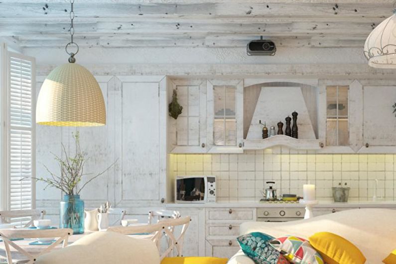 A white kitchen and living room with yellow accents.