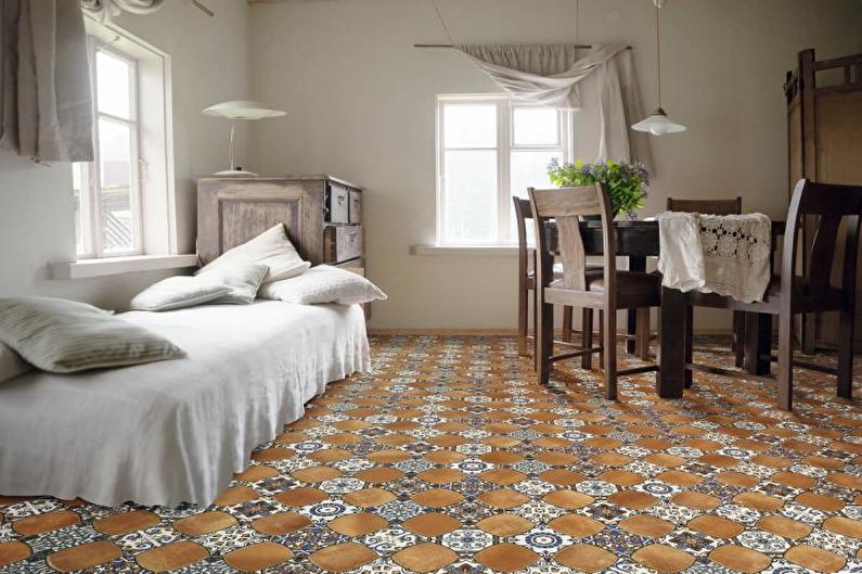 A room with a white table and chairs and a brown tile floor.