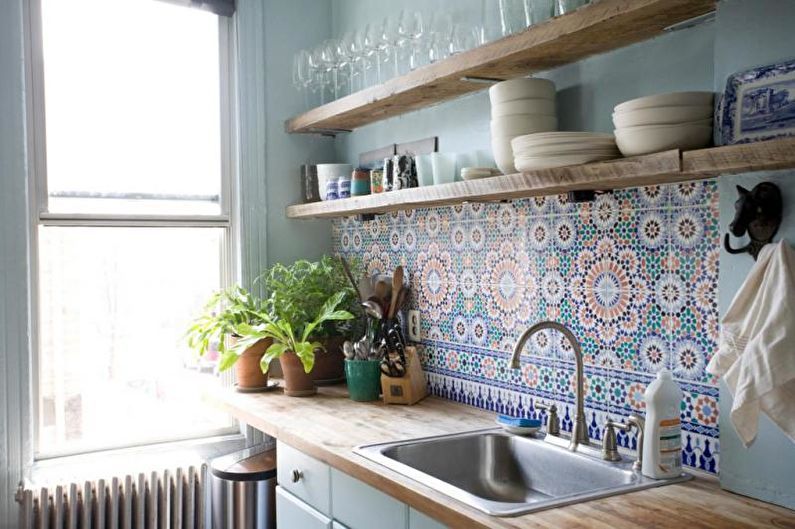 A blue kitchen with tiled walls and a sink.