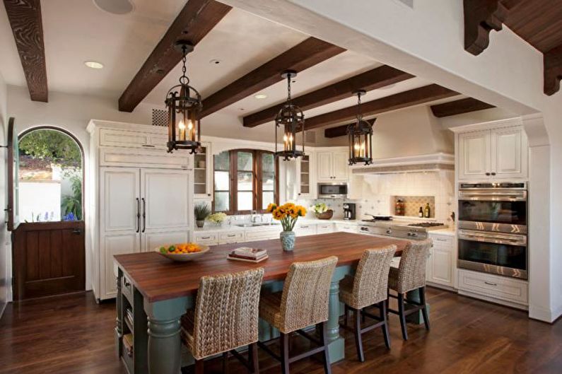 A kitchen with wooden beams and wood floors.