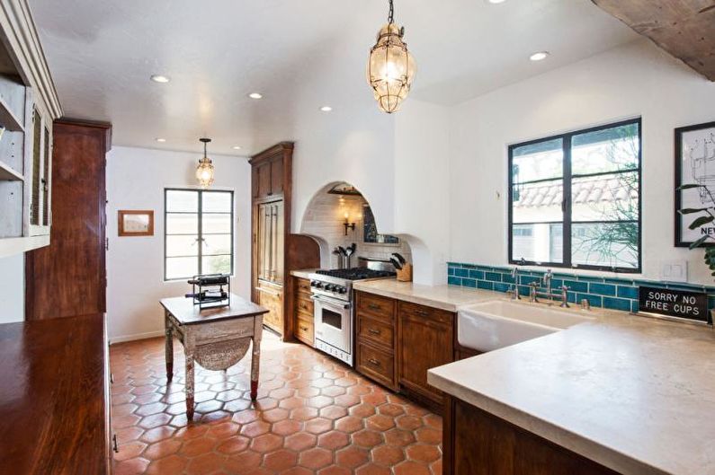 A kitchen with a tiled floor and wooden cabinets.