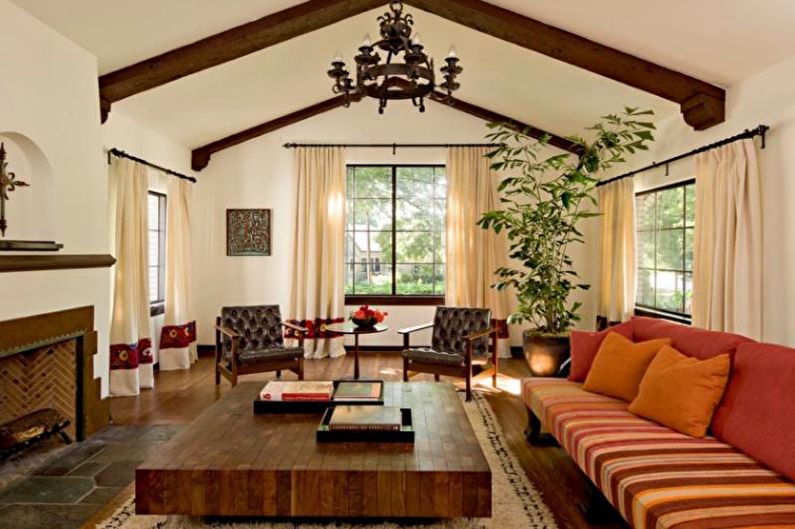 A living room with wooden beams and a fireplace.