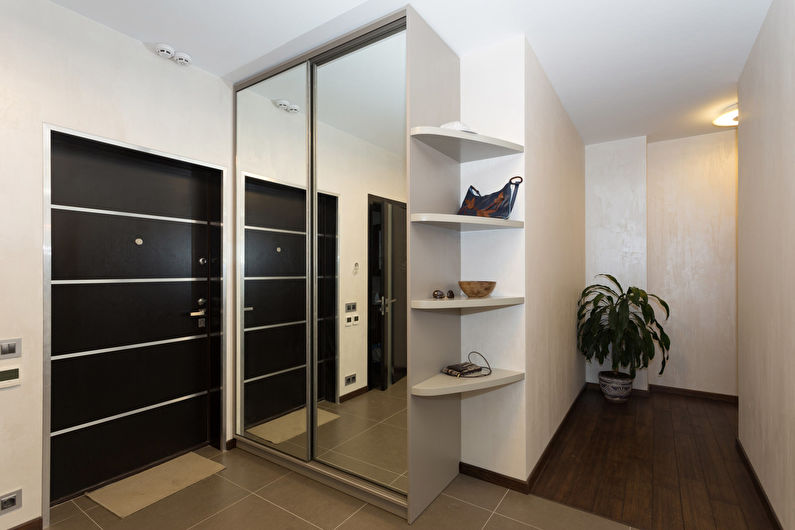 A white staircase in a kitchen with stainless steel railings.