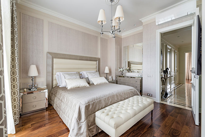 A bedroom with a white bed and a chandelier.
