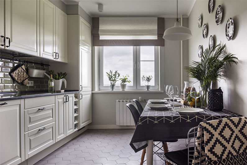 A white and black kitchen with a table and chairs.