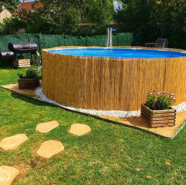 A backyard with a wooden pool surrounded by grass.