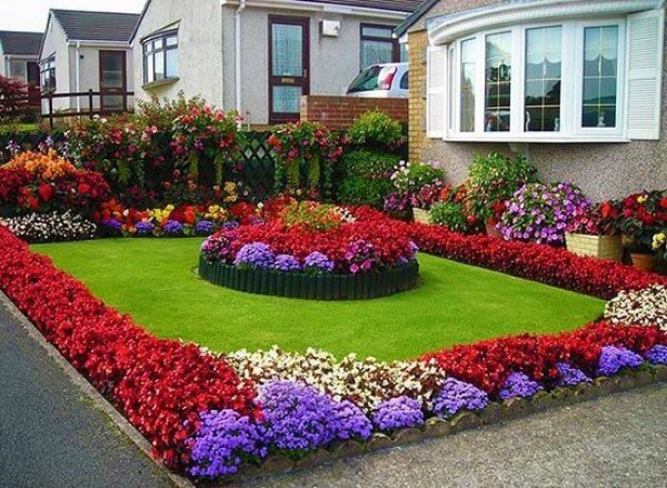 A colorful flower bed in front of a house.
