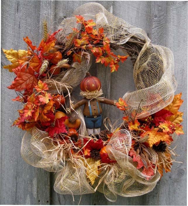 A fall wreath with leaves and a pumpkin.