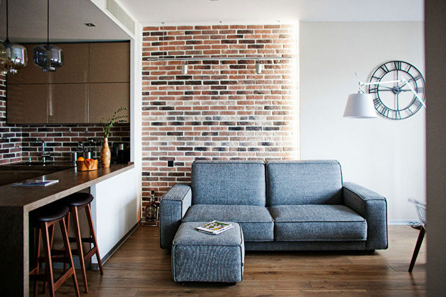 A living room with a brick wall and a couch.