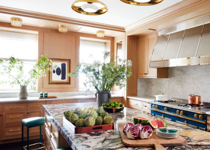 A kitchen with marble counter tops and blue stools.