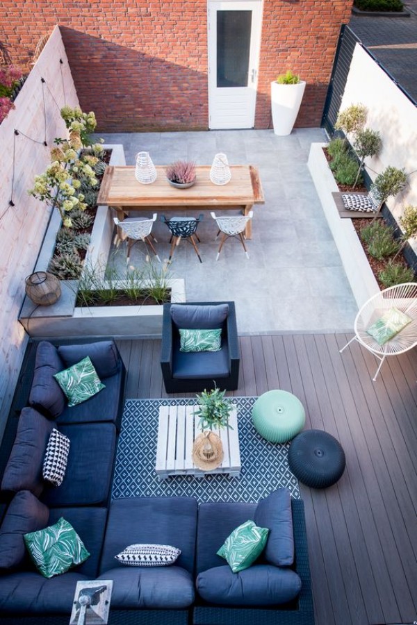 An aerial view of a rooftop patio with furniture and plants.