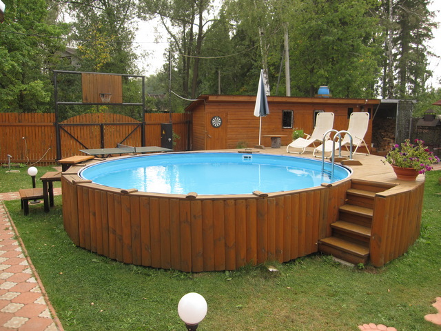 A wooden swimming pool in a backyard.