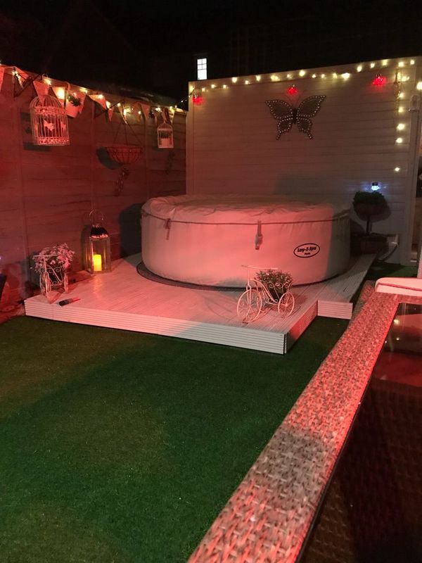 A hot tub in a garden at night.