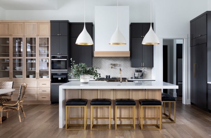 A modern kitchen with black cabinets and gold accents.