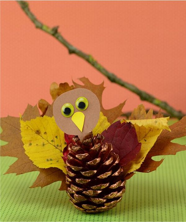 A paper turkey made from pine cones and leaves.