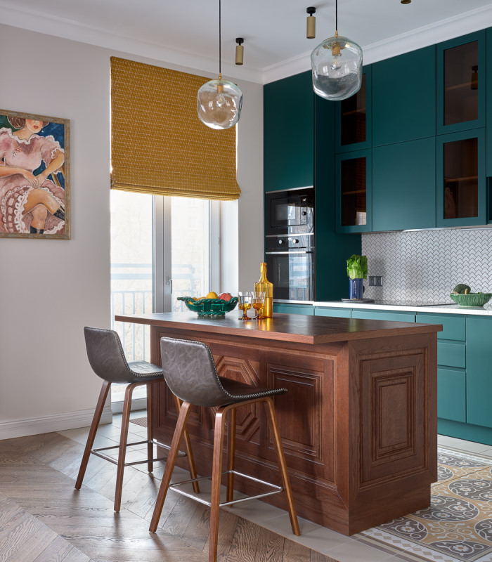 A kitchen with teal cabinets and stools.