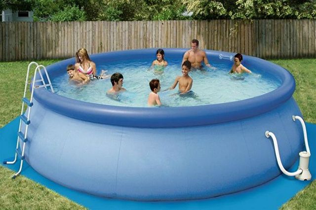 A group of people playing in an inflatable pool.