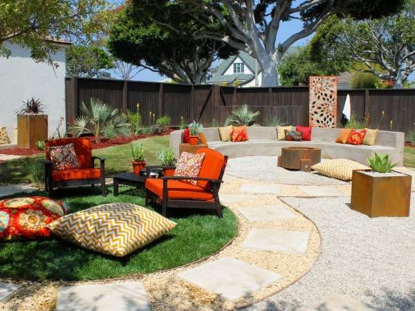 A backyard with orange furniture and a fire pit.