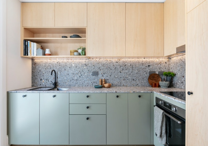 A small kitchen with green cabinets and a stove.