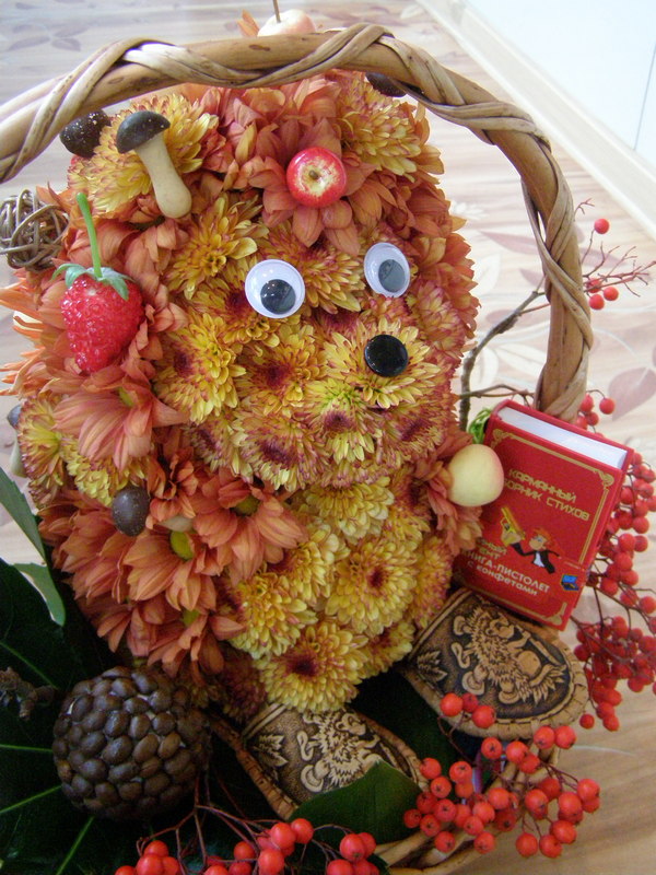 A basket of flowers with a hedgehog in it.