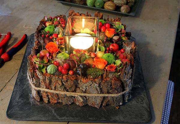 A cake made out of a tree trunk with a candle in the middle.