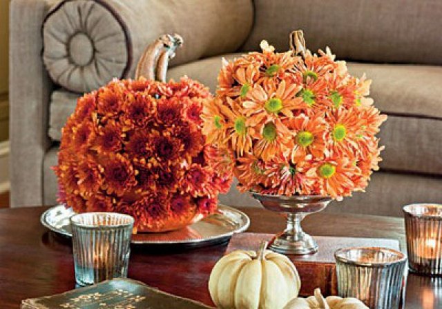 Two pumpkins on a coffee table with candles.