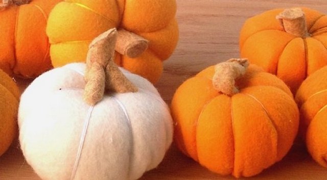 A group of felt pumpkins on a table.