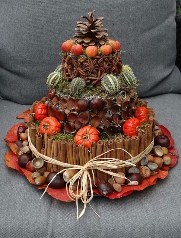 A three tier cake decorated with pine cones and pinecones.