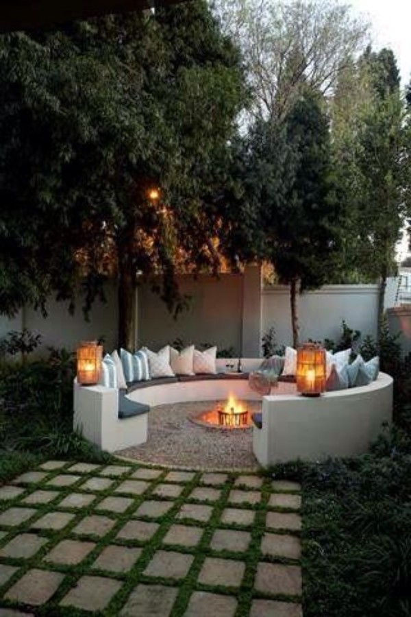 A circular fire pit in the middle of a yard.