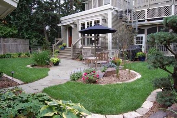 A small backyard with a patio and chairs.