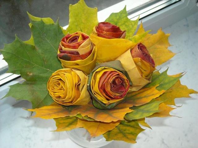 A bouquet of autumn colored roses sitting on a window sill.