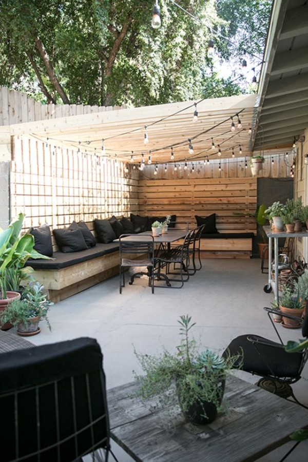 A backyard patio with black furniture and plants.