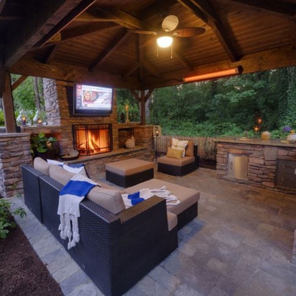 An outdoor living area with a fireplace and tv.