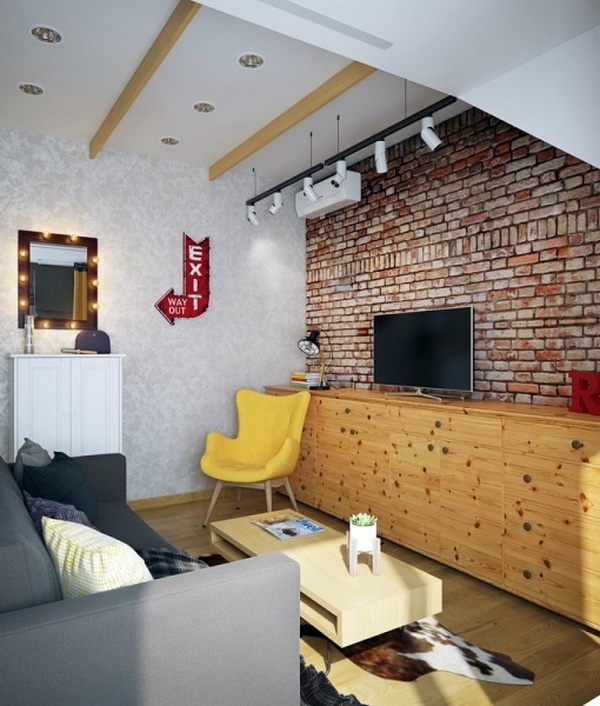 A living room with a brick wall and yellow furniture.