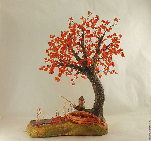 A sculpture of an orange tree with a bird on it.