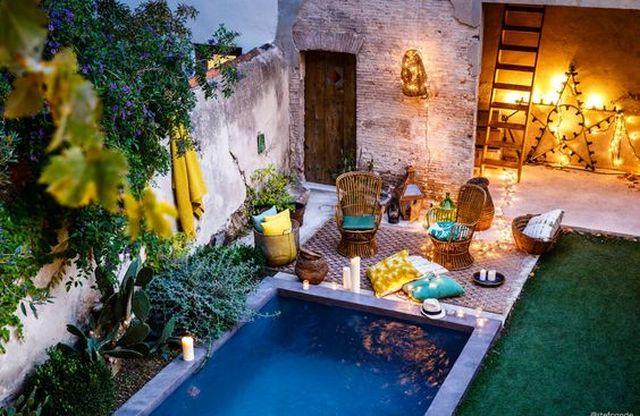 A small courtyard with a pool and lighting.