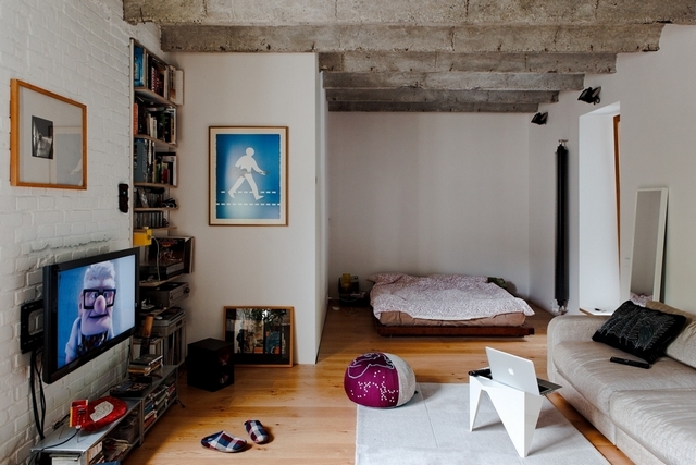 A living room with a tv and bookshelves.