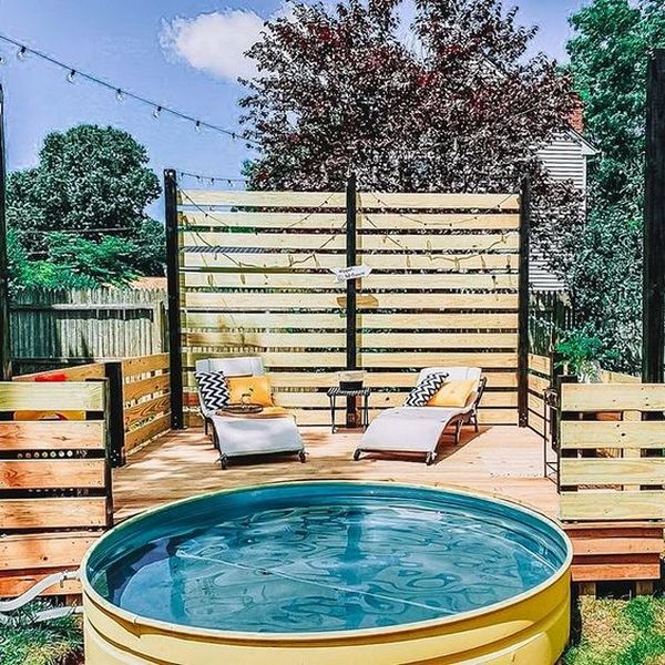 A backyard with a pool and lounge chairs.