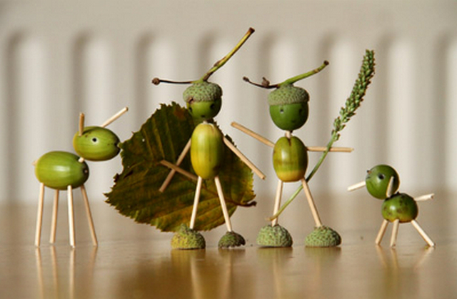 A group of stick figures with leaves and acorns.