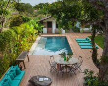 A wooden deck with a pool and lounge chairs.