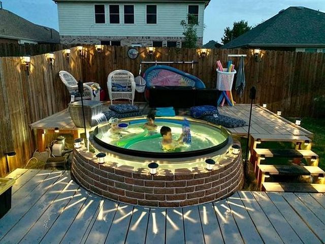 A backyard with a hot tub and lights.