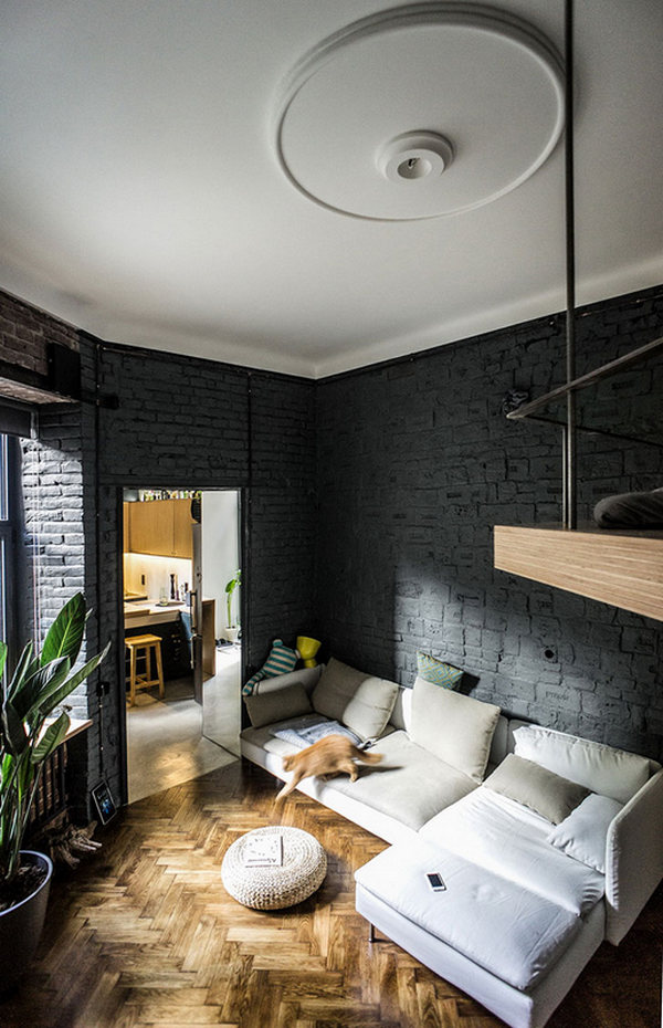 A living room with black walls and wooden floors.