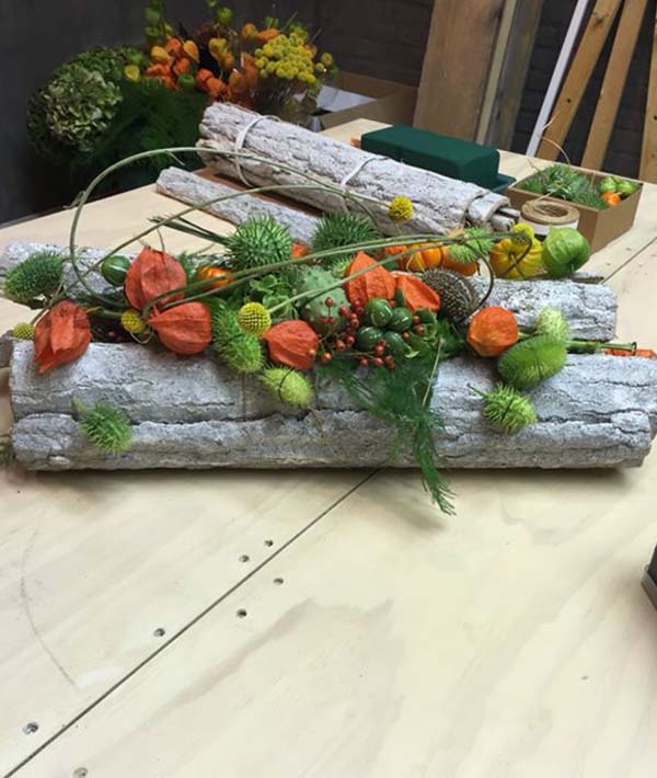 A bunch of flowers and leaves on a wooden table.