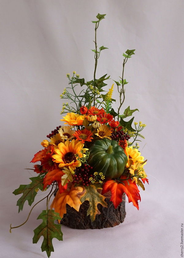 A fall arrangement with pumpkins, leaves, and acorns.