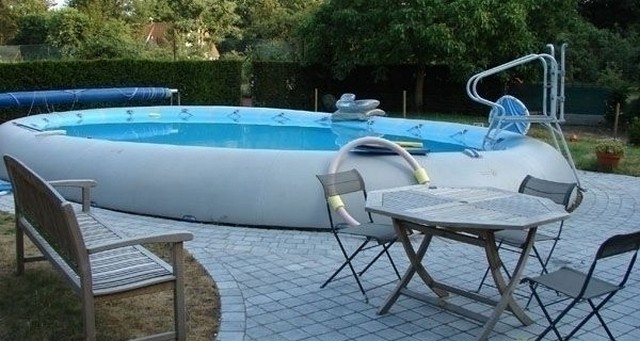 An inflatable swimming pool in a backyard.